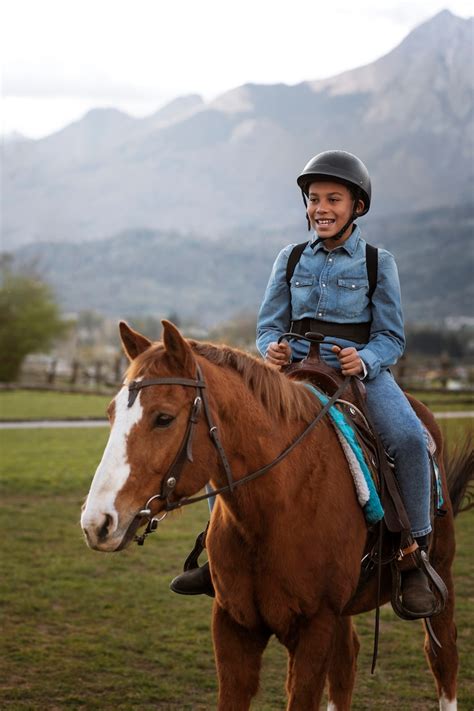 Enfant apprenant à monter à cheval avec un instructeur