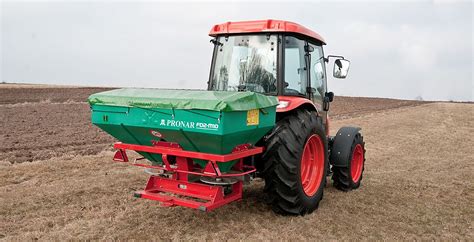 Tracteur avec un épandeur à compost auto-construit