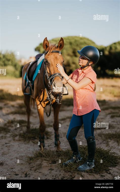 Une jeune fille caressant un poney