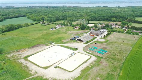 Vue aérienne d'une ferme équestre avec des paddocks et un manège