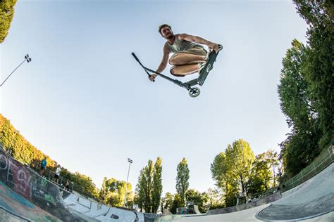 Adolescent faisant une figure en trottinette freestyle dans un skatepark