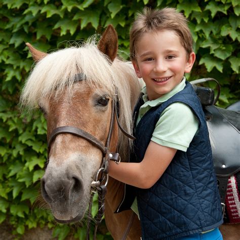 Enfant sur un poney avec un parent