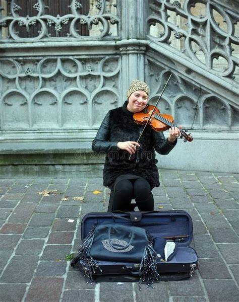 Vieille photographie d'un musicien de rue avec un violon singulier