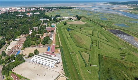 Vue panoramique du Club CSO Le Touquet avec des pistes et des chevaux