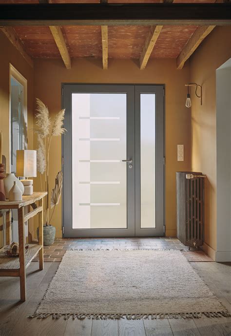 Vue intérieure d'un hall d'entrée lumineux grâce à une porte avec une grande tierce vitrée
