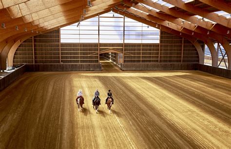 Un groupe de cavaliers traversant un manège couvert