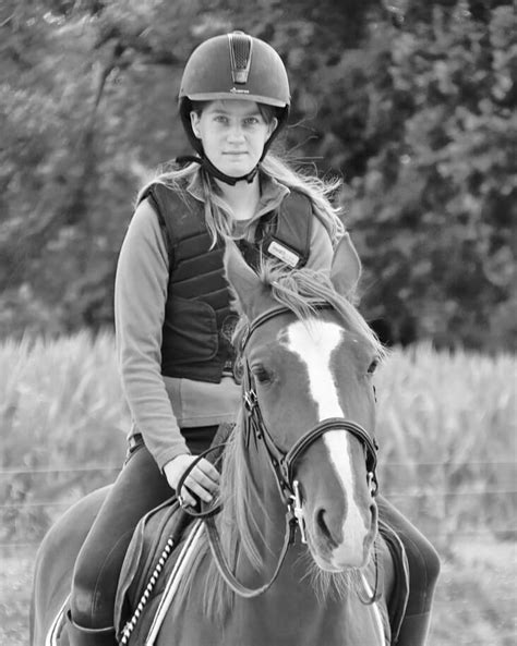 Élèves en tenue d'équitation interagissant avec des chevaux dans un manège