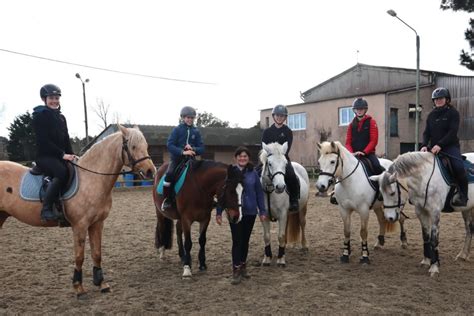 Monique donnant des instructions à de jeunes cavalières lors d'un cours d'équitation en extérieur