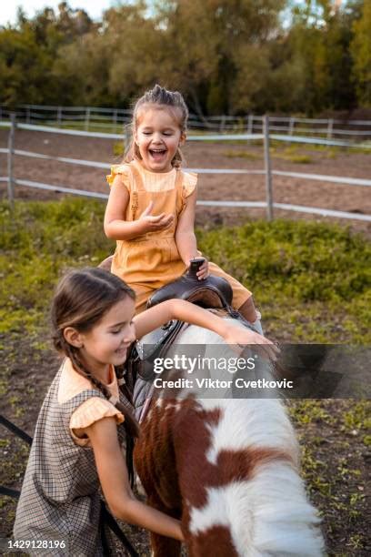 Enfants souriants caressant un poney