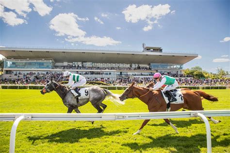Une photo d'un hippodrome animé avec des chevaux au galop