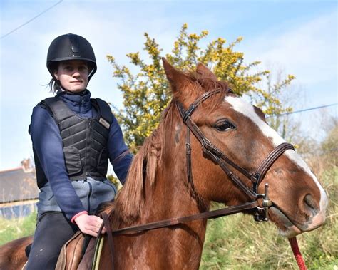 Cavalier filmant avec une caméra sur le torse, gilet de protection visible