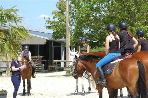 Cavaliers adultes riant pendant un cours d'équitation
