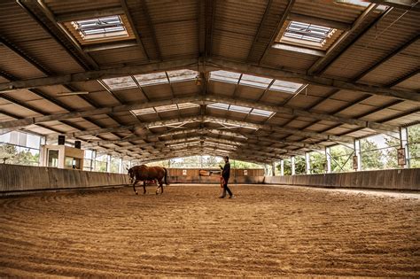 Intérieur d'un manège couvert avec des chevaux et des cavaliers
