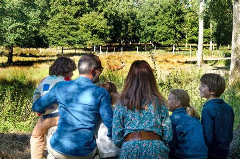 Photo d'une famille observant une course de trot, avec des enfants souriants