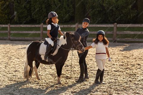 Photo de cavaliers de différents âges apprenant à monter à cheval
