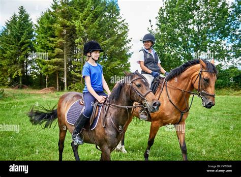 Jeune fille à cheval portant un blouson d'équitation rose