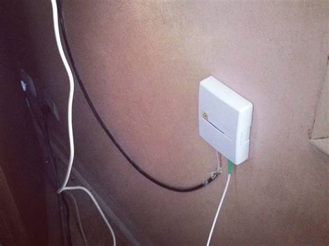 Image d'un technicien installant une prise fibre optique murale