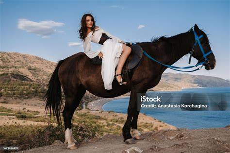 Une jeune fille en selle sur un cheval cabré