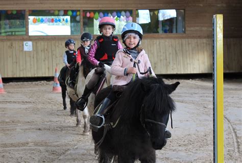 Enfants montant des poneys dans un centre équestre