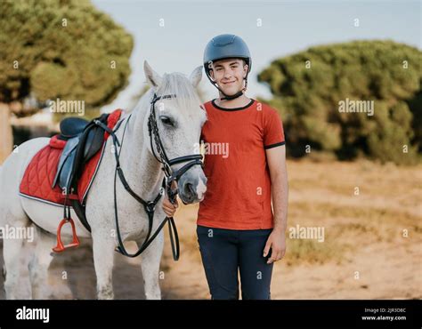 Photo d'un jeune cavalier souriant avec son poney après une épreuve