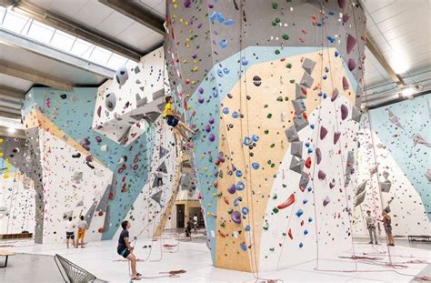 Intérieur d'une salle d'escalade B'Up avec des murs colorés et des grimpeurs
