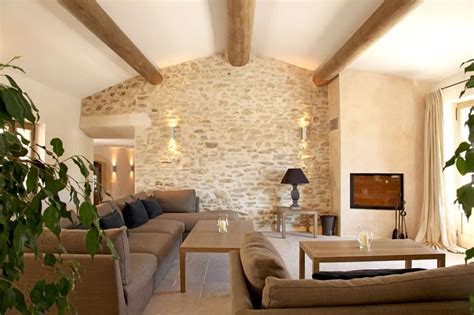 Intérieur d'un gîte rénové avec murs en pierre et mobilier confortable