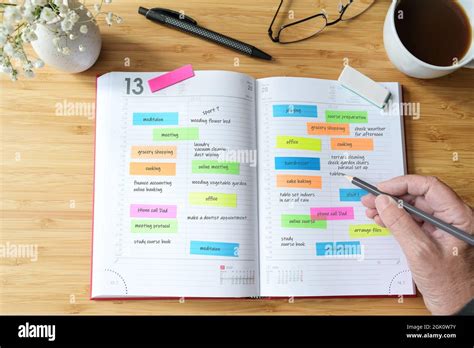 Une main écrivant dans un agenda avec des autocollants de poneys