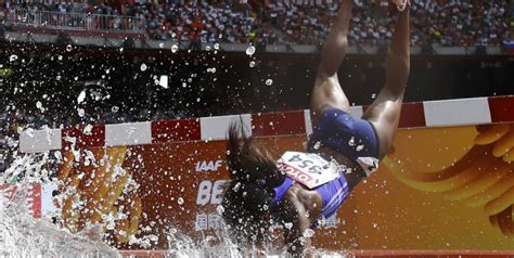 athlète féminine courant en 3000m steeple avec obstacles