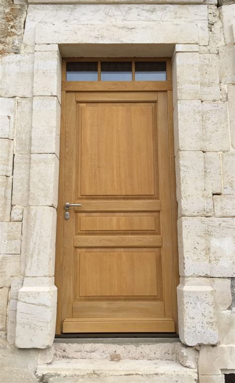 Une porte d'entrée en bois massif avec une tierce vitrée décorative